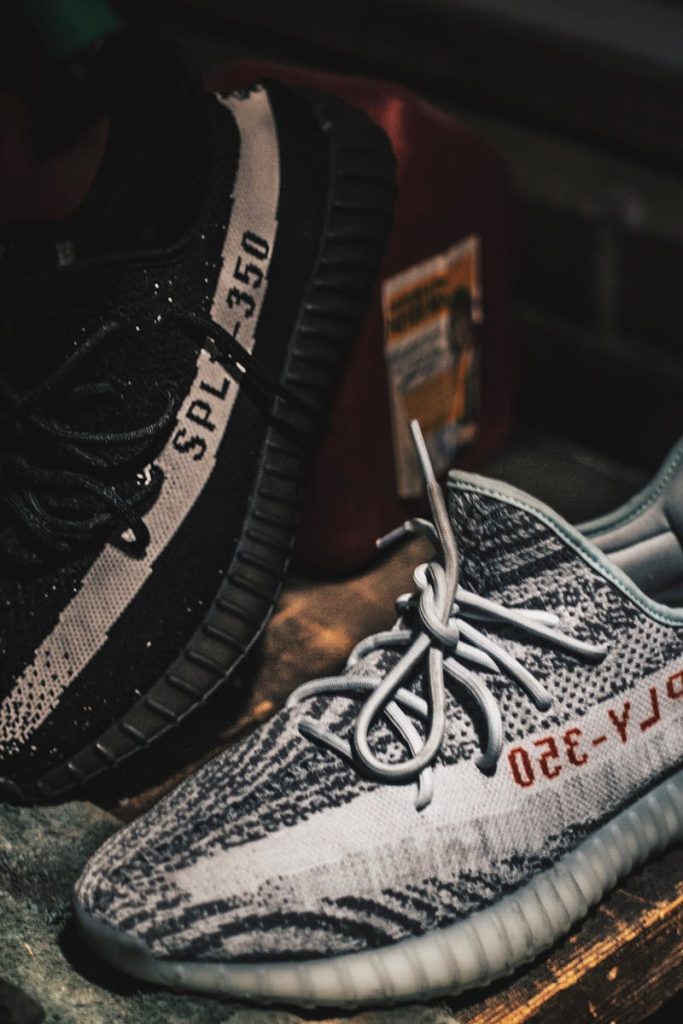 Close-up of Adidas Yeezy sneakers displaying unique design and style on a rustic table.