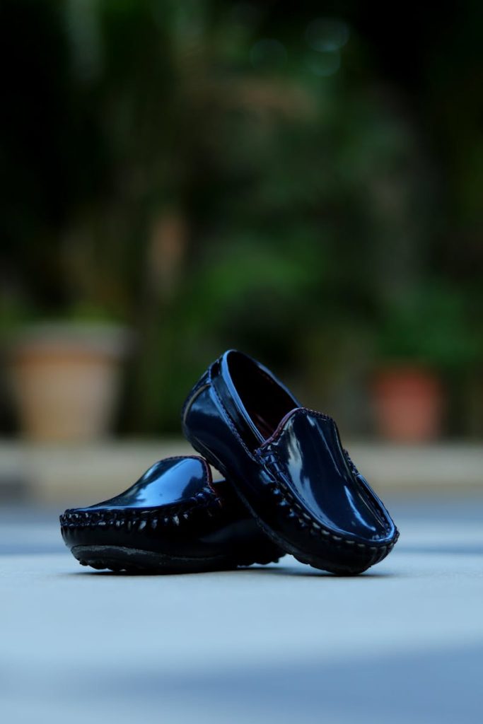 Black loafers pair stylishly displayed outdoors in a vibrant setting.